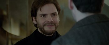 Movie still from “The Face of an Angel” (2014), directed by Michael Winterbottom – A person with a beard looking at the camera; Close Up shot, Over the shoulder angle