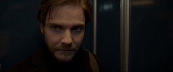 Movie still from “The Face of an Angel” (2014), directed by Michael Winterbottom – A person with a beard and mustache; Close Up shot, Over the shoulder angle