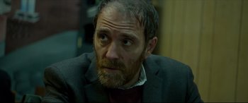 Movie still from “The Face of an Angel” (2014), directed by Michael Winterbottom – A person wearing a suit and tie; Close Up shot, Over the shoulder angle