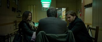 Movie still from “The Face of an Angel” (2014), directed by Michael Winterbottom – A group of people sitting in a room talking to each other; Medium shot, Over the shoulder angle