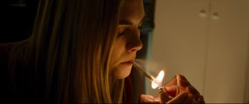 Movie still from “The Face of an Angel” (2014), directed by Michael Winterbottom – A woman lighting a cigarette with a lighter; Close Up shot, High angle