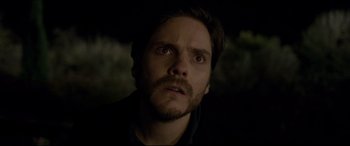 Movie still from “The Face of an Angel” (2014), directed by Michael Winterbottom – A person with a beard looking at the camera; Close Up shot, Over the shoulder angle