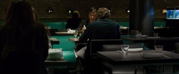 Movie still from “The Face of an Angel” (2014), directed by Michael Winterbottom – Two people are sitting at a table in a restaurant; Medium shot, Over the shoulder angle