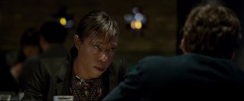 Movie still from “The Face of an Angel” (2014), directed by Michael Winterbottom – A woman sitting in front of a man in a black jacket; Close Up shot, Over the shoulder angle