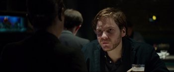 Movie still from “The Face of an Angel” (2014), directed by Michael Winterbottom – A man in a black shirt is looking at the camera; Close Up shot, Over the shoulder angle