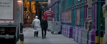 Movie still from “The Face of an Angel” (2014), directed by Michael Winterbottom – Two people walking down the sidewalk in the city; Wide shot, Over the shoulder angle
