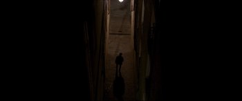 Movie still from “The Face of an Angel” (2014), directed by Michael Winterbottom – A person walking down a dark hallway at night; Extreme Wide shot, High angle