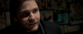 Movie still from “The Face of an Angel” (2014), directed by Michael Winterbottom – A person wearing a suit and tie; Close Up shot, Over the shoulder angle