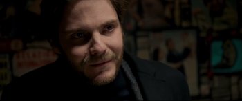 Movie still from “The Face of an Angel” (2014), directed by Michael Winterbottom – A person wearing a suit and tie; Close Up shot, Over the shoulder angle