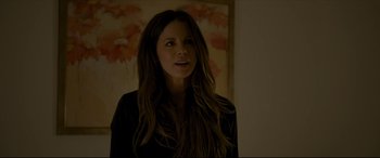 Movie still from “The Face of an Angel” (2014), directed by Michael Winterbottom – A woman with long hair standing in front of a painting; Close Up shot, Over the shoulder angle