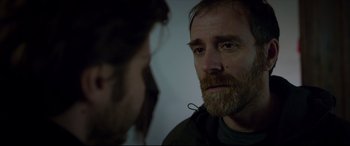 Movie still from “The Face of an Angel” (2014), directed by Michael Winterbottom – A man with a long beard looking at another man with long hair; Close Up shot, Over the shoulder angle
