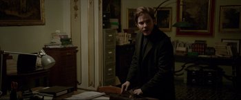 Movie still from “The Face of an Angel” (2014), directed by Michael Winterbottom – A man in a black coat is holding a knife in his hand; Medium shot, Over the shoulder angle