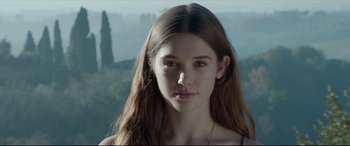 Movie still from “The Face of an Angel” (2014), directed by Michael Winterbottom – A young woman with long hair is looking at the camera; Close Up shot, Low angle