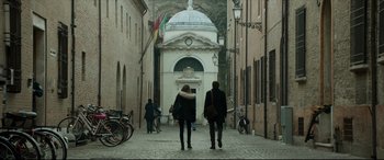 Movie still from “The Face of an Angel” (2014), directed by Michael Winterbottom – Two people walking down a narrow street in a city; Wide shot, Low angle