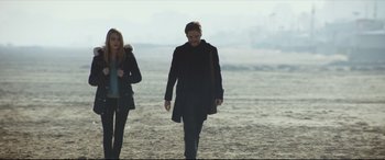 Movie still from “The Face of an Angel” (2014), directed by Michael Winterbottom – A man and a woman walking on the beach; Wide shot, Low angle