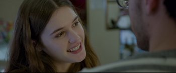 Movie still from “The Face of an Angel” (2014), directed by Michael Winterbottom – A woman smiles while looking at a computer screen; Close Up shot, Over the shoulder angle