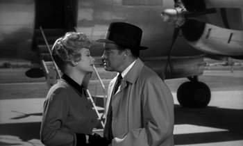 Movie still from “The Facts of Life” (1960), directed by Melvin Frank – A man and a woman standing next to each other in front of an airplane; Medium shot, Over the shoulder angle