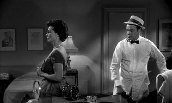 Movie still from “The Facts of Life” (1960), directed by Melvin Frank – A man and a woman standing next to each other in a room; Medium shot, Low angle