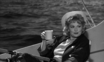 Movie still from “The Facts of Life” (1960), directed by Melvin Frank – A black and white photo of a woman holding a coffee cup; Medium shot, High angle