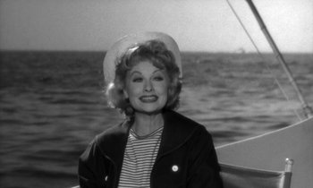 Movie still from “The Facts of Life” (1960), directed by Melvin Frank – An old black and white photo of a woman on a boat; Medium shot, High angle
