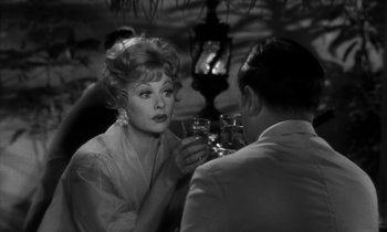 Movie still from “The Facts of Life” (1960), directed by Melvin Frank – A woman sitting at a table with a man drinking wine; Close Up shot, Over the shoulder angle
