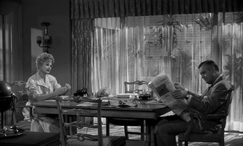 Movie still from “The Facts of Life” (1960), directed by Melvin Frank – Two people are sitting at a table reading newspapers; Wide shot, Over the shoulder angle