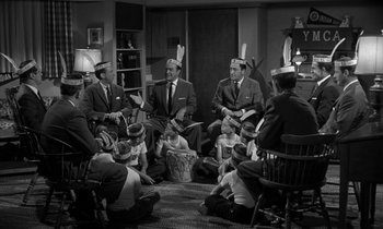 Movie still from “The Facts of Life” (1960), directed by Melvin Frank – A black and white photo of a group of men sitting in a circle; Medium shot, High angle