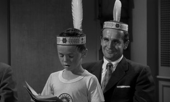 Movie still from “The Facts of Life” (1960), directed by Melvin Frank – A man and a young boy wearing feather headbands; Medium shot, Over the shoulder angle