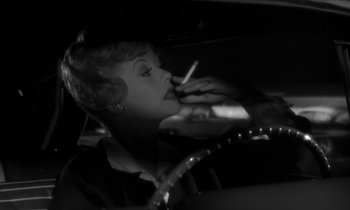 Movie still from “The Facts of Life” (1960), directed by Melvin Frank – A woman smoking a cigarette while sitting in a car; Close Up shot, Over the shoulder angle