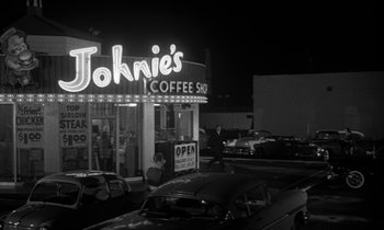 Movie still from “The Facts of Life” (1960), directed by Melvin Frank – A black and white photo of a coffee shop at night; Wide shot, High angle