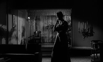 Movie still from “The Facts of Life” (1960), directed by Melvin Frank – A woman standing in front of a window in a room; Wide shot, Low angle