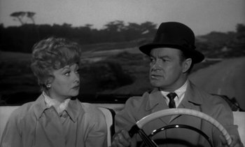 Movie still from “The Facts of Life” (1960), directed by Melvin Frank – A man and a woman sitting at a steering wheel in a car; Medium shot, Over the shoulder angle