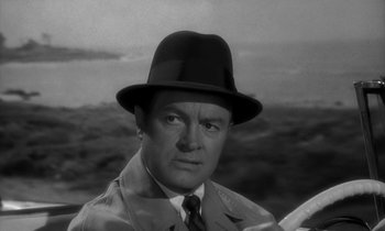 Movie still from “The Facts of Life” (1960), directed by Melvin Frank – A man wearing a hat and a trench coat; Close Up shot, Over the shoulder angle