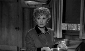 Movie still from “The Facts of Life” (1960), directed by Melvin Frank – A woman in a black and white photo holding a bowl; Medium shot, Low angle