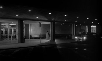 Movie still from “The Facts of Life” (1960), directed by Melvin Frank – A person walking in a parking lot at night; Extreme Wide shot, Low angle