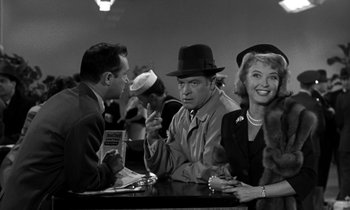 Movie still from “The Facts of Life” (1960), directed by Melvin Frank – A group of people sitting at a table; Medium shot, Over the shoulder angle