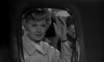 Movie still from “The Facts of Life” (1960), directed by Melvin Frank – An old photo of a woman in a car waving; Close Up shot, Over the shoulder angle