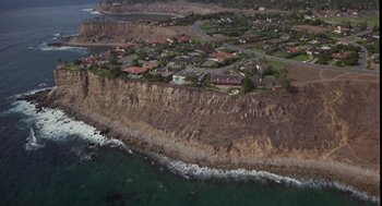 Movie still from “The Falcon and the Snowman” (1985), directed by John Schlesinger – An aerial view of a beach and a cliff; Extreme Wide shot, High angle