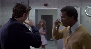 Movie still from “The Falcon and the Snowman” (1985), directed by John Schlesinger – Two men are drinking wine in a hallway; Medium shot, Over the shoulder angle