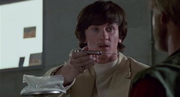 Movie still from “The Falcon and the Snowman” (1985), directed by John Schlesinger – A man holding a cell phone in his hand; Close Up shot, Low angle