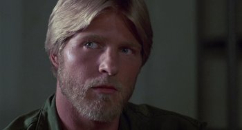 Movie still from “The Falcon and the Snowman” (1985), directed by John Schlesinger – A person with long hair and a beard; Close Up shot, Over the shoulder angle