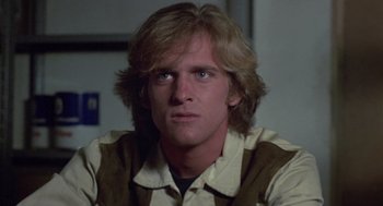 Movie still from “The Falcon and the Snowman” (1985), directed by John Schlesinger – A person with long blonde hair; Close Up shot, Low angle