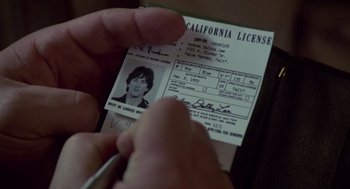 Movie still from “The Falcon and the Snowman” (1985), directed by John Schlesinger – A person is holding a california license; Extreme Close Up shot, High angle