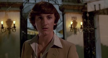 Movie still from “The Falcon and the Snowman” (1985), directed by John Schlesinger – A young man with long brown hair wearing a brown jacket; Close Up shot, Low angle