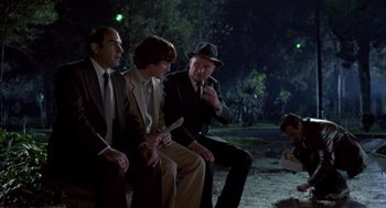 Movie still from “The Falcon and the Snowman” (1985), directed by John Schlesinger – A group of men sitting next to each other on a bench; Wide shot, High angle