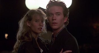 Movie still from “The Falcon and the Snowman” (1985), directed by John Schlesinger – A man and a woman posing for a picture; Close Up shot, Low angle