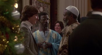 Movie still from “The Falcon and the Snowman” (1985), directed by John Schlesinger – A group of men standing next to each other in a room; Medium shot, Over the shoulder angle