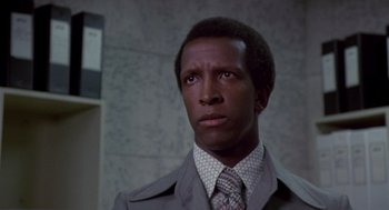 Movie still from “The Falcon and the Snowman” (1985), directed by John Schlesinger – A person wearing a suit and tie; Close Up shot, Low angle