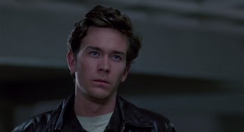 Movie still from “The Falcon and the Snowman” (1985), directed by John Schlesinger – A person wearing a leather jacket; Close Up shot, Over the shoulder angle