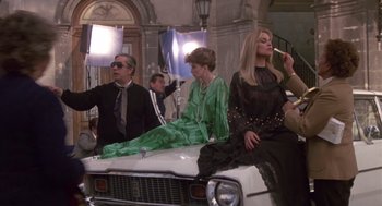 Movie still from “The Falcon and the Snowman” (1985), directed by John Schlesinger – A group of people sitting on top of a white car; Wide shot, Low angle